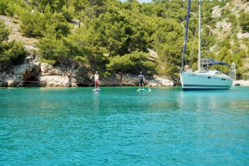 Türkise Bucht und Boot und SUP-Paddler