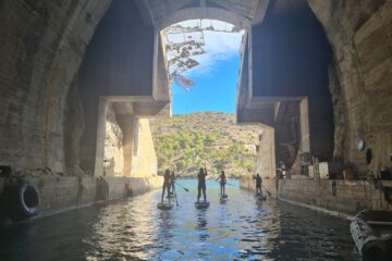 Gruppe durchquert auf SUP ein Gewölbe