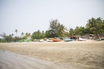 Sandstrand mit Booten und Palmen