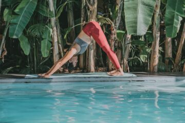 Frau macht Yoga am Pool