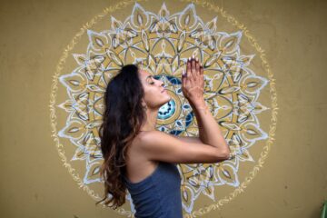 Frau vor Mandala in Gebetspose