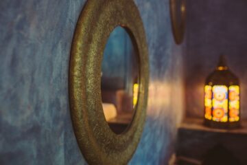 Spiegel an blauer Wand und indische Lampe