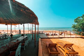Restaurant und Terrasse mit Liegen am Strand und Meer