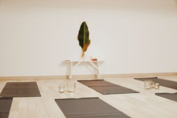 Yogamatten auf Boden und Bananenblatt an der Wand