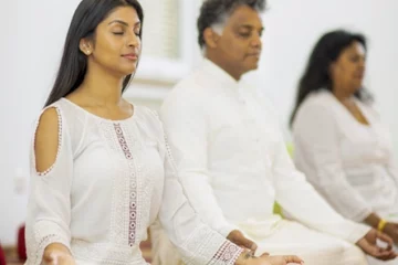 Mann und zwei Frauen beim Meditieren