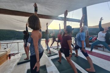 Gruppe übt Yoga an Deck