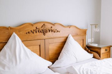 Holzbett mit weißen Kissen