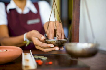 Eine singhalesische Hotel-Mitarbeiterin bereitet ayurvedische Medizin vor.