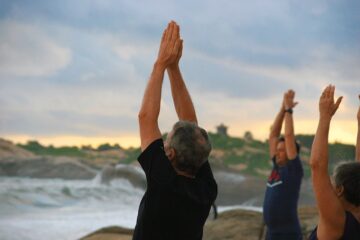 Eine Gruppe von Menschen praktiziert Yoga am Meer