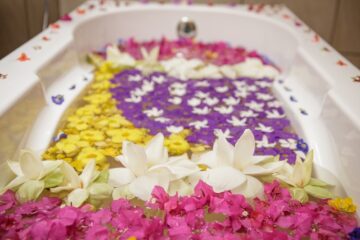 Eine Badewanne voll mit weißen, rosafarbigen, gelben und lila Blumen