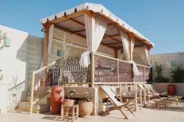 Liegestühle und überdachter Sitzbereich auf einer Dachterrasse in Marokko