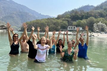 Ein Gruppe von Reisenden badet im Ganges Fluss in Rishikesh, Indien.