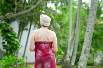 Frau läuft durch eine Gartenanlage mit Palmen