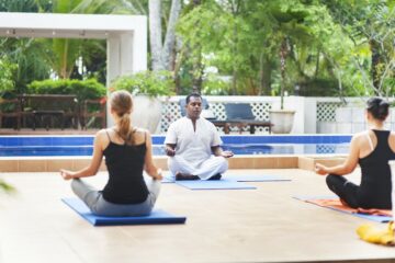 Eine Gruppe von drei Menschen bei einer gemeinsamen Meditation in Sri Lanka in einem Hotel.