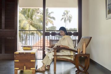 Indische Frau liest eine Zeitung in einem Stuhl