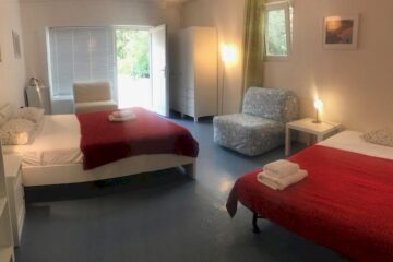 Zwei Doppelbetten mit Sessel und Balkon