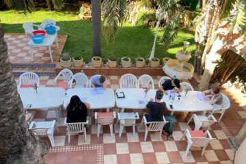 Menschen auf Stühlen an einem Tisch in einem Garten