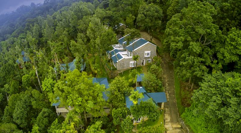 Luftaufnahme mehrerer Gebäude in einem Wald in Indien