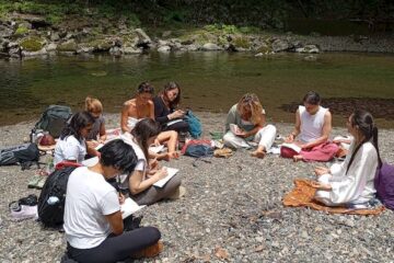 Eine Gruppe von Menschen beim Schreiben oder Zeichnen an einem Fluss in Japan