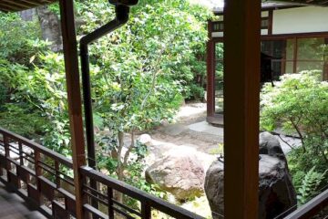 Überdachte Holzveranda (Engawa) in traditioneller japanischer Architektur. Von hier aus blickt man auf einen wunderschön angelegten japanischen Garten.