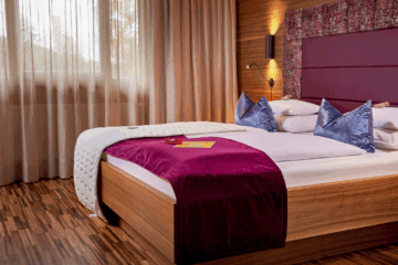 Die Premium-Zimmer mit privater Gartenterrasse sind ein ruhiger, naturnaher Rückzugsort für anspruchsvolle Gäste. Sie sind klimatisiert und hochwertig ausgestattet mit Naturstein-Waschbecken, barrierefreier Dusche und begehbarer Garderobe. TV/SAT, WLAN und Safe sorgen für zeitgemäßen Komfort, während die unmittelbare Nähe zu Spa und Restaurants fließende Übergänge zwischen Entspannung und Genuss ermöglicht. Außerdem steht dir das hauseigene Tee-Set zur Verfügung.